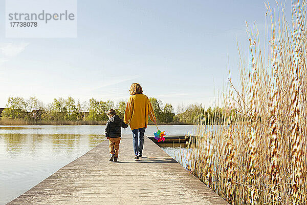 Mutter und Sohn gehen auf Steg über See