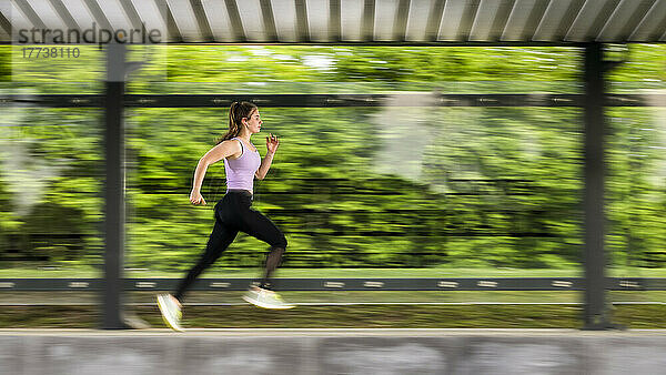 Young sportswoman running in park