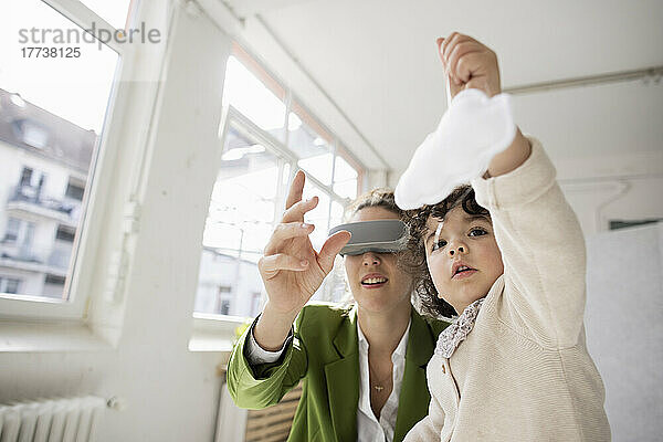 Mother and daughter exploring the metaverse in the cloud using virtual reality simulator
