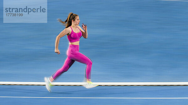 Young sportswoman sprinting on running track