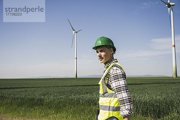 Ingenieur mit Schutzhelm steht auf dem Feld