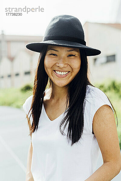 Glückliche schöne Frau mit Hut an einem sonnigen Tag