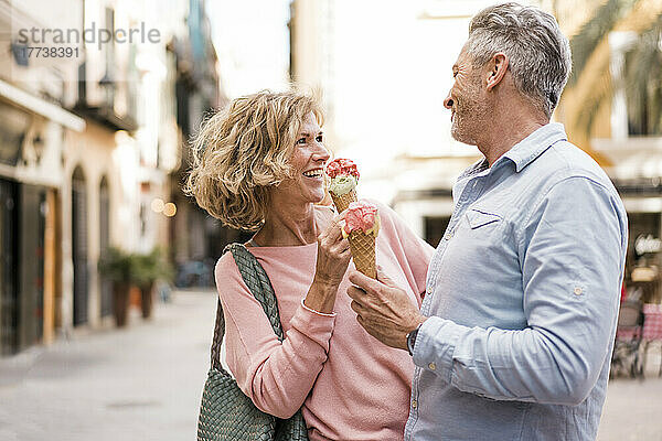 Glückliches älteres Paar beim Eisessen in der Stadt