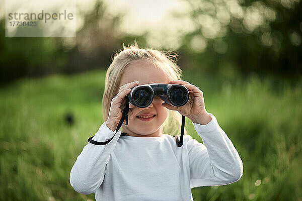 Girl looking through binoculars on weekend