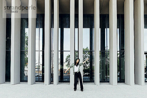Young woman standing in front of columns