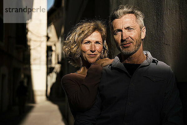 Selbstbewusstes älteres Paar inmitten von Mauern an einem sonnigen Tag