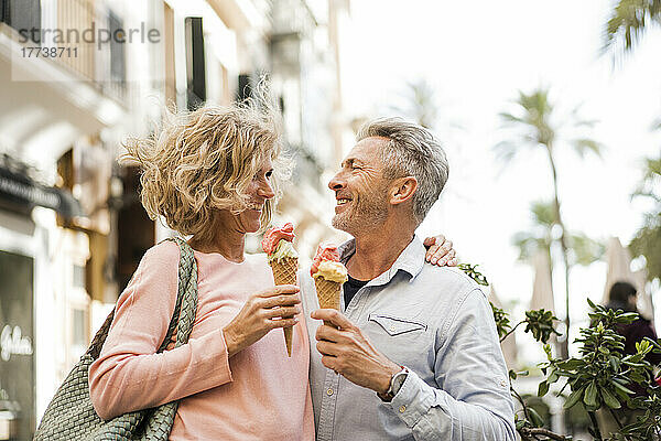 Glückliches älteres Paar beim Eisessen in der Stadt