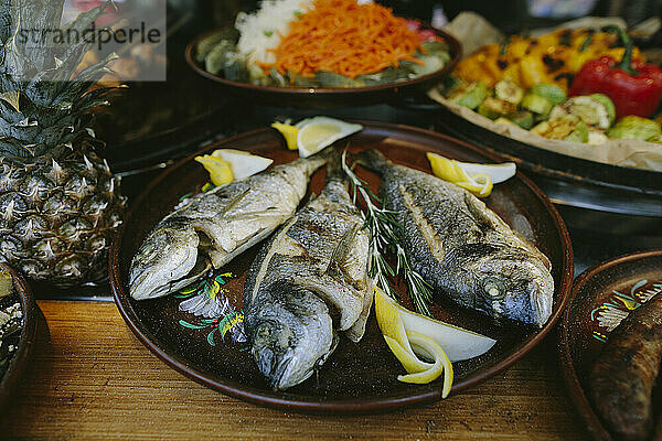 Frischer Fisch wird auf einem Teller auf dem Tisch serviert