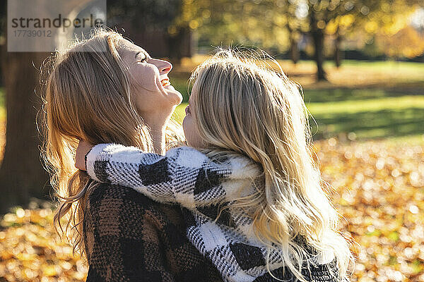 Glückliche Mutter und Tochter genießen den Herbstpark