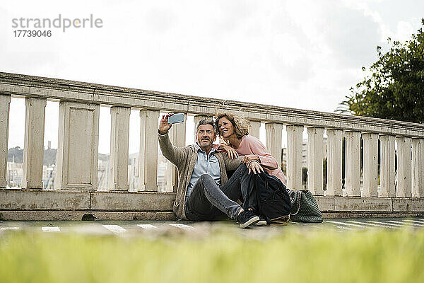 Touristen machen ein Selfie mit ihrem Mobiltelefon auf einer Brücke