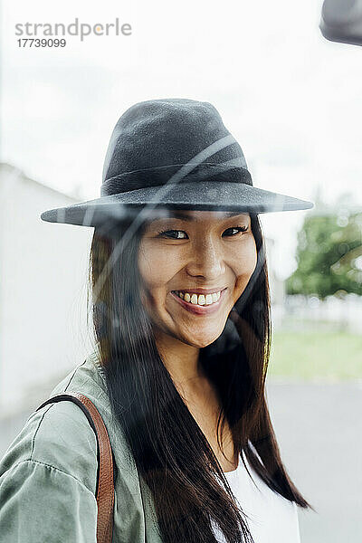 Lächelnde schöne junge Frau mit Hut