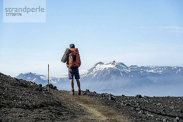 Wanderer auf Wanderweg durch vulkanische Landschaft  hinten verschneite Berggipfel  Wanderweg Fimmvörðuháls  Þórsmörk Nature Reserve  Suðurland  Island  Europa