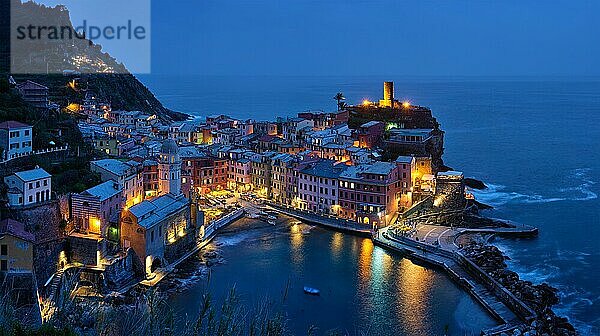 Blick auf das Dorf Vernazza  beliebtes Touristenziel im Nationalpark Cinque Terre  einem UNESCO-Weltkulturerbe  Ligurien  Italien  beleuchtet in der Nacht vom Azure-Weg aus  Europa