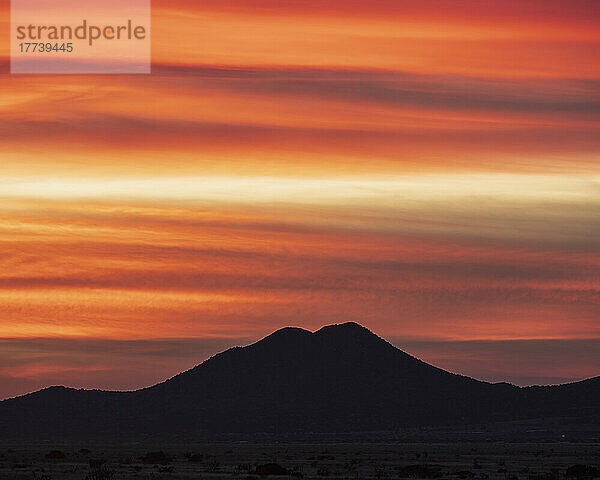 USA  New Mexico  Santa Fe  Silhouette eines Berges vor orangefarbenem Himmel bei Sonnenuntergang