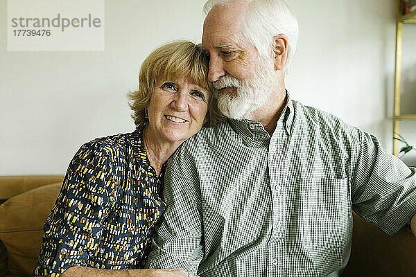 Porträt eines lächelnden älteren Paares auf dem Sofa