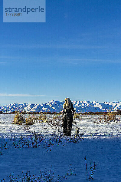 USA  Idaho  Bellevue  ältere blonde Frau beim Schneeschuhwandern in schneebedeckter Landschaft