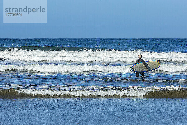 Älterer Surfer mit Surfbrett