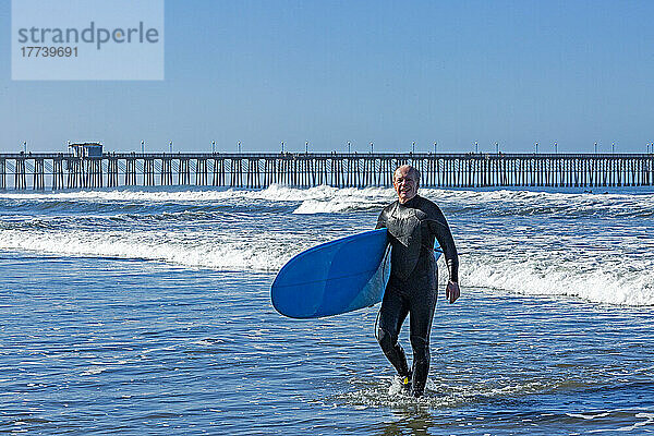 USA  Kalifornien  Oceanside  Senior Surfer mit Surfbrett