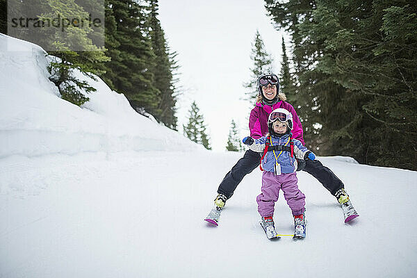 Kleines Mädchen (2-3) lernt mit Mutter Skifahren