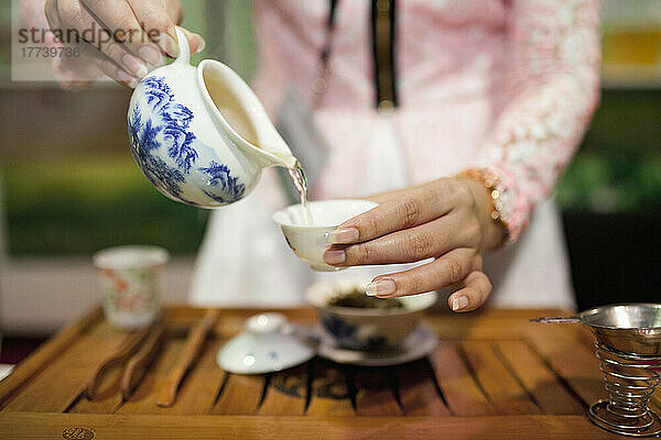 Frau gießt Tee ein
