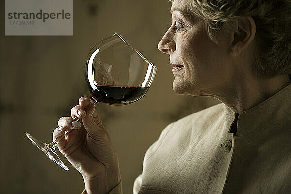 Frau riecht an einem Glas Rotwein