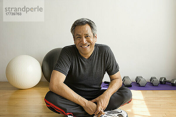 Porträt eines Mannes  der im Fitnessstudio sitzt