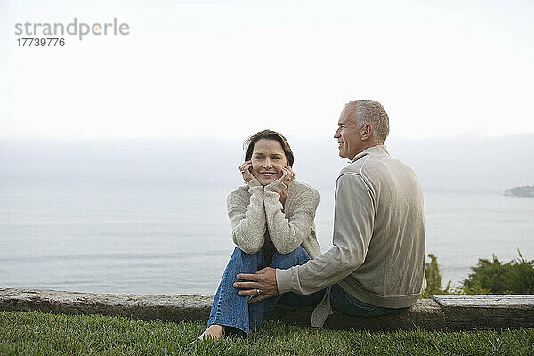 Älteres Paar sitzt an der Küste