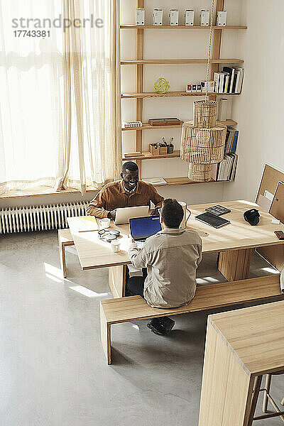 Männliche Programmierer diskutieren am Schreibtisch im Büro eines Start-up-Unternehmens