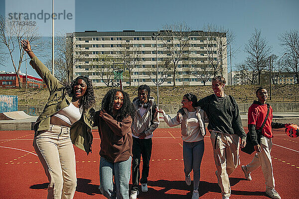 Fröhliche multirassische Freunde  die sich an einem sonnigen Tag auf einem Sportplatz vergnügen