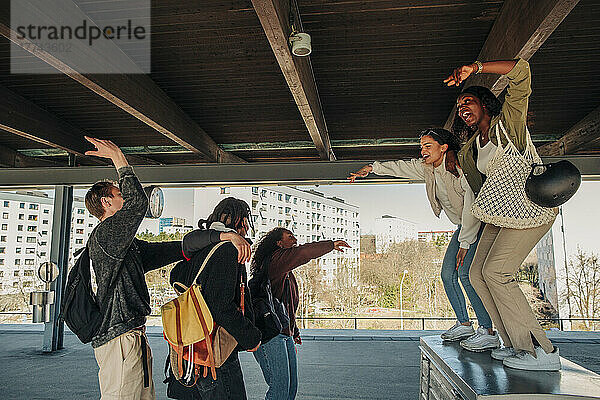 Unbekümmerte Freundinnen tanzen auf dem Bahnhof