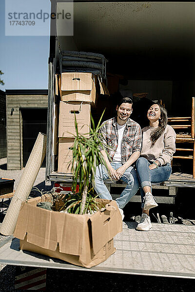 Porträt eines glücklichen Paares im Lieferwagen an einem sonnigen Tag