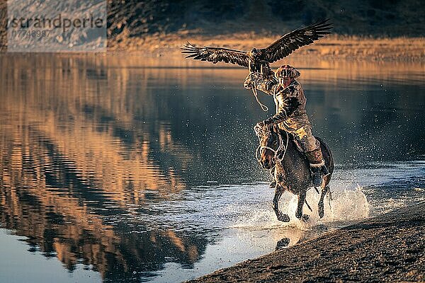 Junger Adlerjäger Reiten auf dem Tolbo-See in der westlichen Mongolei