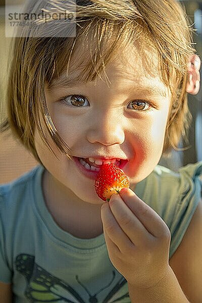 Mädchen im Kleinkindalter ißt eine Erdbeere