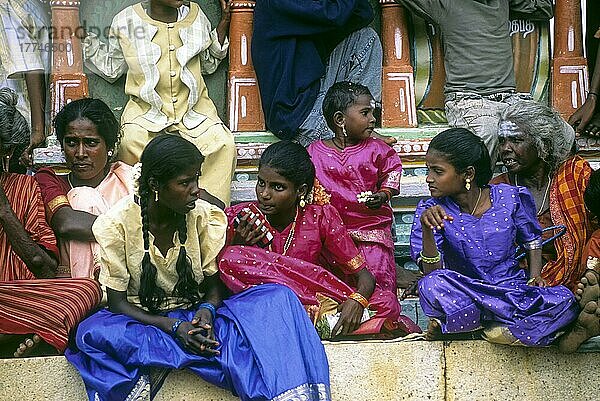 Dorfmädchen und Frauen sitzen während des Sivarathri-Festes in einem Dorf in Tamil Nadu  Indien  unter dem Fuß der Ayyanar-Statue  Asien