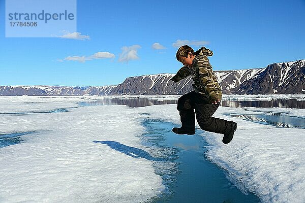 Inuit-Junge springt über Spalte in Eisscholle  Ellesmer  Eskimo  Inuitjunge  Eskimojunge  Ureinwohner  freistellbar  Island  Kanada  Nordamerika