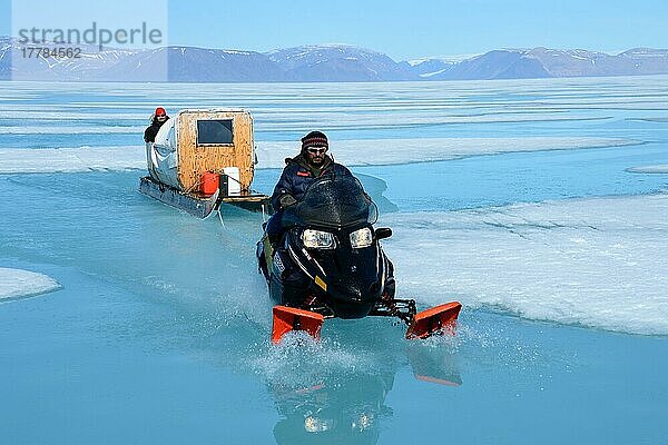 Inuits auf Schneemobil fahren Touristen in Schlitten über Meereis  Ellesmer  Eskimo  Ureinwohner  Island  Kanada  Nordamerika
