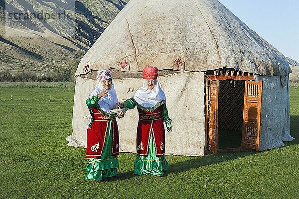 Zwei kasachische Frauen in traditioneller Kleidung vor einer Jurte  die Gäste mit Süßigkeiten begrüßen  Nur für den redaktionellen Gebrauch  Dorf Sati  Tien-Shan-Gebirge  Kasachstan  Asien