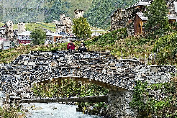 Georgisches Paar aus einer Folkloregruppe auf einer Steinbrücke vor dem Dorf Ushguli  Nur für redaktionelle Zwecke  Ushguli  Region Svaneti  Georgien  Asien
