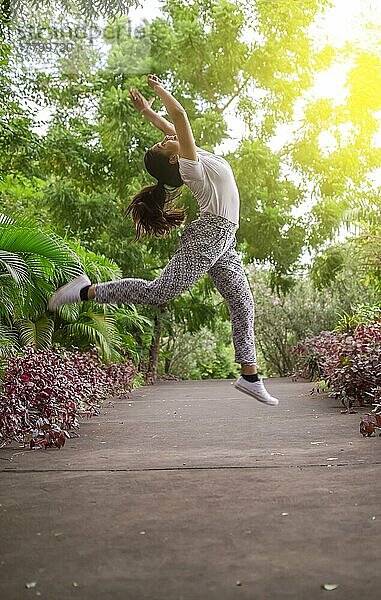 Mädchen springt umgeben von Bäumen  Konzept der glücklichen Mädchen springen