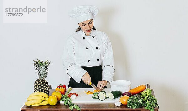 Eine Köchin  die frisches Gemüse schneidet  Konzept einer Köchin  die frisches Gemüse zubereitet. Porträt einer Köchin  die Gemüse schneidet  Köchin  die Salat zubereitet