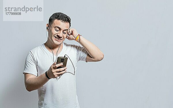 Person hört Musik mit seinem Handy mit Kopfhörern isoliert  Handsome Mann genießt Musik mit Kopfhörern isoliert  fröhlicher Kerl hört Musik mit seinem Handy isoliert