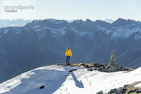 Bergsteigerin blickt über schneebedeckte Berge  Wanderung zum Guffert  Brandenberger Alpen  Tirol  Österreich  Europa