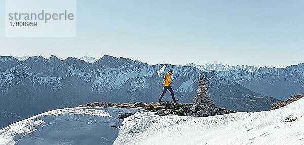 Bergsteigerin blickt über schneebedeckte Berge  Wanderung zum Guffert  Brandenberger Alpen  Tirol  Österreich  Europa