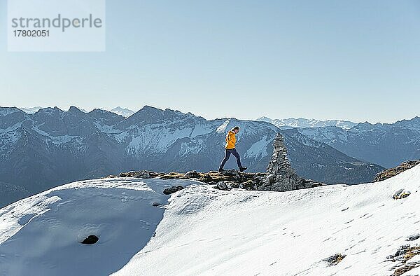 Bergsteigerin blickt über schneebedeckte Berge  Wanderung zum Guffert  Brandenberger Alpen  Tirol  Österreich  Europa