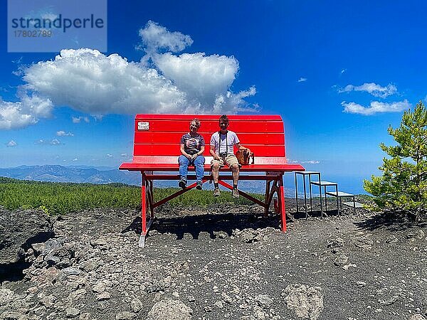 2 Personen sitzen auf riesiger roter Bank  Big Bench Community Project  Big Bench Number 200  Ätna  Grande Panchina  Linguaglossa  Sizilien  Italien  Europa