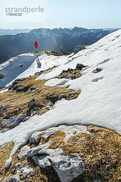 Bergsteiger neben einem Steinmännchen  vor verschneiten Bergen des Rofan  Wanderweg zum Guffert mit erstem Schnee  im Herbst  Brandenberger Alpen  Tirol  Österreich  Europa