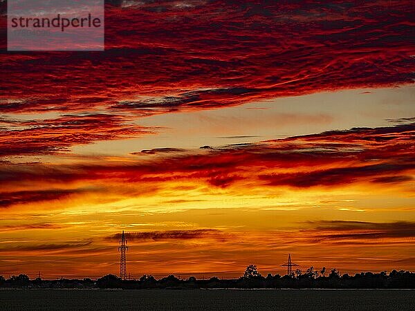 Sonnenuntergang mit rot gefärbten Wolken am Abend der Sonnenwende  Braunschweig  Niedersachsen  Deutschland  Europa