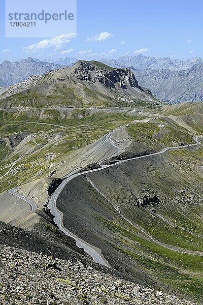 Blick vom Cime de la Bonette auf hochalpine Berglandschaft mit Alpenpass Col de la Bonette in der Mitte  im Vordergrund Ringstraße um Cime de la Bonette  Nationalpark Mercantour  Jausiers  Departement Alpes-de-Haute-Provence  Frankreich  Europa