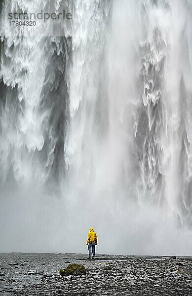 Mensch vor großem Wasserfall  Skógafoss  Südisland  Island  Europa