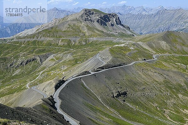 Blick vom Cime de la Bonette auf hochalpine Berglandschaft mit Alpenpass Col de la Bonette in der Mitte  im Vordergrund Ringstraße um Cime de la Bonette  Nationalpark Mercantour  Jausiers  Departement Alpes-de-Haute-Provence  Frankreich  Europa